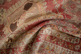 Distressed Anatolian rug runner with folded texture showing madder root red, pale raspberry, and silver arabesque designs.