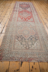 Distressed Anatolian runner viewed lengthwise, showing a series of faded red and charcoal medallions.