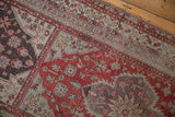 Intricate geometric and floral borders in cherry red and silver on a distressed Turkish runner.