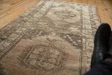 Vintage distressed Oushak runner with soft beige tones, time-worn texture, and faded motifs.