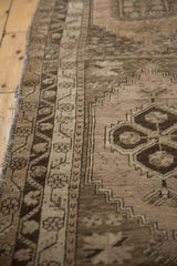 Distressed texture, time-softened beige and charcoal patterns on a vintage Oushak rug.