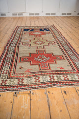 Angled view of a vintage Caucasian runner, showing the alignment of its triple stepped geometric medallions.