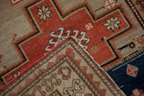 A folded corner showing the crab-style border and stepped medallion on a vintage Caucasian runner.