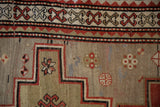 Even wear across the hand-knotted pile of a vintage Caucasian rug with a geometric crab border.