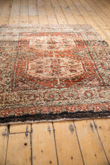 Plush pile and dark selvage of a vintage Tulu rug, revealing a repeating floral border.