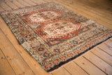 Vintage Tulu rug corner, showing repeating floral border, latch motif, and thick ivory, rust abrash pile.