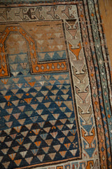 Vintage Caucasian rug corner with inverted triangular patterns, prayer Mehrab, and abrash tones.