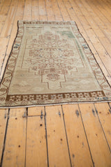 Vintage distressed Oushak rug end showing faded brown border and even pile texture.