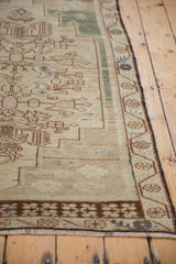 Distressed Oushak rug corner with coffee brown main border, ivory field, and even worn pile.