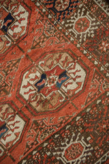 Repeating gul motifs and vinery on vintage Afghani Bokhara rug, madder red, coffee brown, ivory, navy, pile wear.
