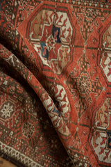 Hand-knotted vintage Afghani Bokhara rug showing madder root red guls and chocolate brown outer border.