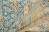 Folded vintage Birjand carpet, showing distressed sky blue and sand Herati motif.