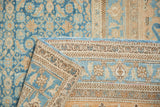 Folded corner of distressed Birjand rug, showing worn Herati pattern, foundation, and side cord.