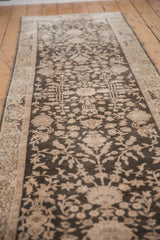 Long view of a distressed Sparta runner showing its sprawling floral pattern in charcoal and ivory.