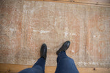 Distressed Oushak rug texture, showing mostly even wear to knot heads and pale terra cotta tones.