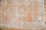 Vintage distressed Oushak rug detail showing textured pile, pale terra cotta, ivory, and subtle wear.