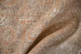 Distressed Oushak rug pile showing mostly even wear and soft terra cotta, ivory tones.