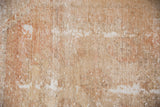 Textured close-up of vintage Oushak runner's distressed pile, with pale terra cotta and ivory.