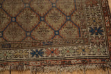 Antique Caucasian rug corner showing tattered fringe, serrated panels, and a blue serpent border.