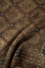 Antique Caucasian rug pile detail showing wear, serrated panels, rust, and indigo hues.