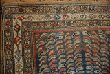 Vintage Caucasian rug corner with distinctive blue ground fish motif and vinery boteh borders.