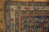 Vintage Caucasian rug corner detail with colorful boteh border on textured blue ground.