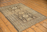 Vintage Caucasian rug corner with charcoal pawn motif border and tattered fringe.
