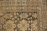 Reciprocating pawn border and geometric starburst motifs on vintage Caucasian rug in charcoal, beige, orange.