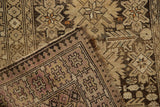 Folded vintage Caucasian rug, showing beige starbursts and a faded lavender pawn motif border.