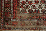 Vintage Caucasian rug corner, geometric ivory, deep blush, gray patterns, worn pile, tattered fringe.