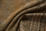 Folded antique Kula rug showcasing repeating pearl motif in camel, sand, and charcoal.