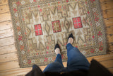 Vintage Caucasian rug's left border with geometric beige, pink, tangerine patterns and intact selvage.