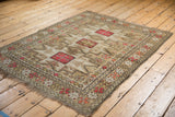 Vintage Caucasian rug corner with geometric border of stylized pink, tangerine, and beige buds.