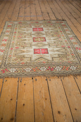 Beige and pink geometric border with quatrefoil buds on vintage Caucasian rug's worn fringe.