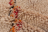 Thick plush pile of a vintage Moroccan carpet with ivory, tangerine orange, and faded cherry red.