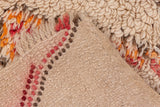 Plush ivory, tangerine, and red hand-knotted pile with textured Moroccan rug foundation.