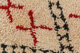 Thick plush pile of the vintage Moroccan rug showing red, ivory, and charcoal geometric patterns.