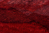 Vintage Moroccan carpet close-up showcasing rich, striated abrash of wine and cherry red pile.