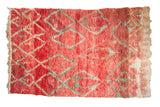 Vintage Moroccan carpet with a playful asymmetric diamond pattern on an abrashed cherry red field.