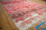 Corner view of a vintage Moroccan carpet highlighting the plush, abrashed red pile and ivory foundation.