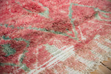 Abrasions in the cherry red pile reveal knot heads and foundation on this Moroccan carpet.