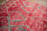 Angled close-up showing the textural, abrashed pile of the cherry red Moroccan carpet.