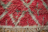 Detail of the secured fringe and hand-knotted wool pile on a vintage Moroccan carpet.