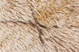 Close-up of the vintage Moroccan rug's thick plush ivory and coffee brown pile.