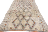 Shaggy ivory vintage Moroccan rug pile, featuring charcoal geometric diamonds with red and saffron accents.