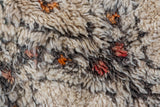 Shaggy vintage Moroccan rug pile in ivory, charcoal, saffron yellow, and pale cherry red.