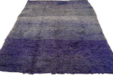 Rich shaggy pile showing striated abrash from deep violet to light blue.