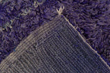 Thick, shaggy violet and royal blue pile revealing the tightly hand-knotted foundation of a Moroccan carpet.