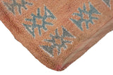 Textured pile and serrated geometric motifs on a vintage Moroccan carpet corner with intact selvage.