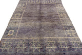 Abrashed violet field and geometric floral starburst pattern on vintage Moroccan carpet.